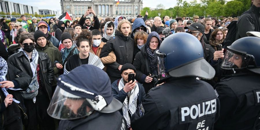 Teilnehmer einer spontanen Unterstützungsversammlung gegen die Räumung des propalästinensischen Protestcamps stehen vor Polizeibeamten.