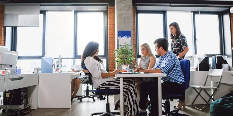 Büro UV Licht Mitarbeitende Schreibtische helle Fenster