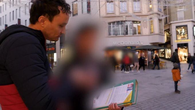 Eine Unterschriftensammlerin wird von einem RTS-Reporter konfrontiert und weiss selbst nicht so genau, wovon sie Passanten überzeugen soll. Unterschriften Sammeln Incop