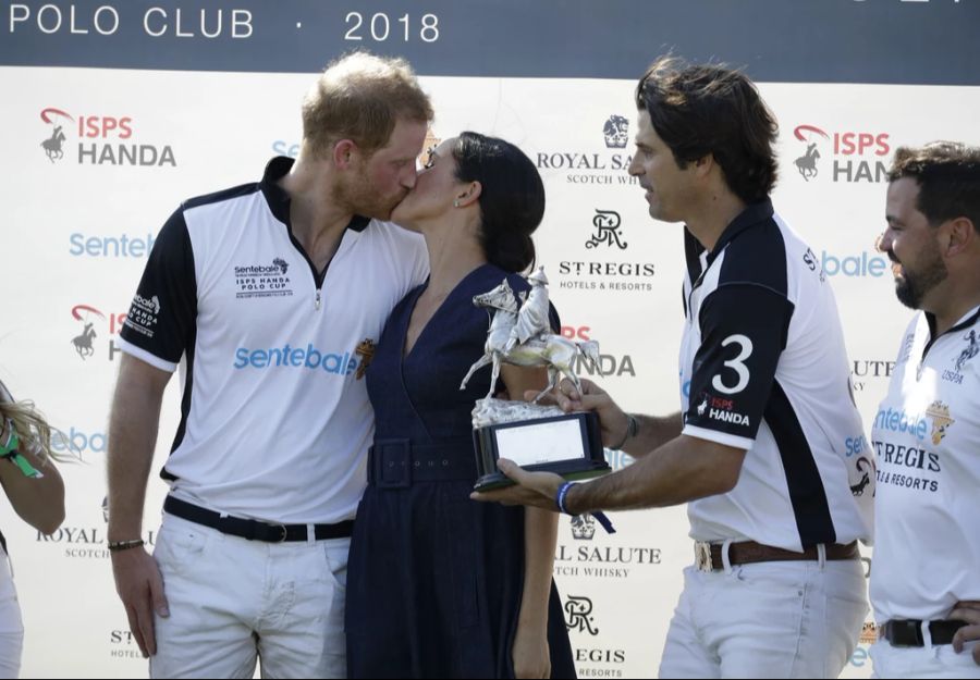 Harry und Meghan küssen sich bei einem Polospiel.