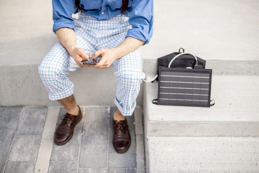 Mann am Smartphone, Solarladegerät