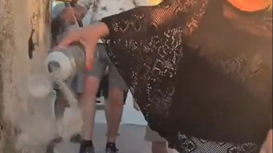 Die mutmasslich britische Gruppe spaziert eine belebte Treppe der Insel hinunter – und verstreut dabei die Asche aus einer Urne.