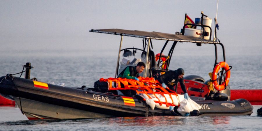 Beamte der Guardia Civil bergen in der spanischen Enklave Ceuta die Leiche eines Migranten aus dem Wasser. Foto: Antonio Sempere/AP/dpa