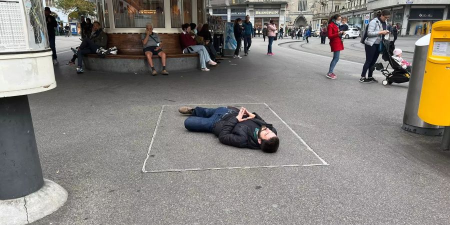 Erste Aktivisten beginnen mit dem Die-In. Es scheint, als würden sie sich tot stellen.