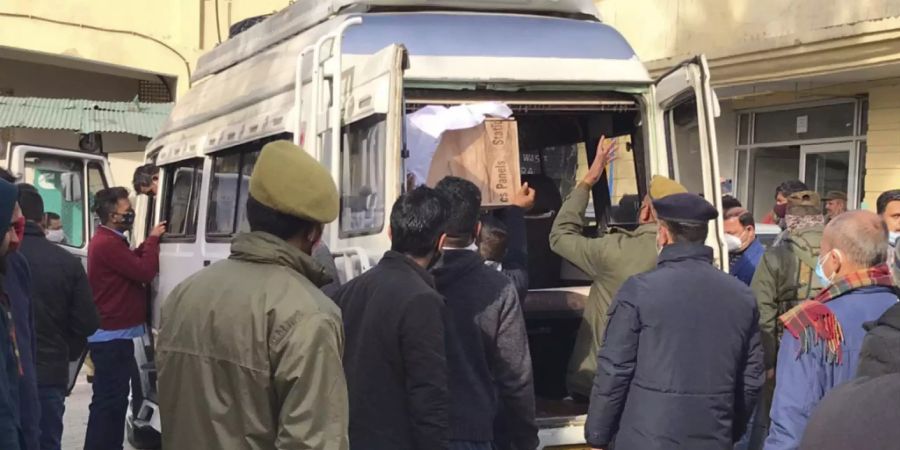 Polizisten helfen beim Verladen des Sarges eines Opfers einer Massenpanik in einem Gesundheitszentrum in Katra, in der Nähe von Jammu, Indien. Foto: Channi Anand/AP/dpa