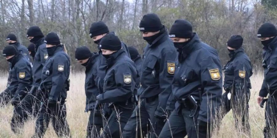 Polizeibeamte suchen auf einer Wiese nach Spuren, nachdem auf dem Gelände eine 16-Jährige tot aufgefunden worden ist. Foto: Lisa Willert/dpa