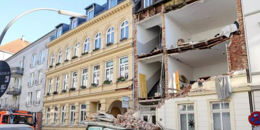 Explosion in Hamburg-Ottensen: Trümmer liegen auf einem Auto vor dem Haus, dessen Fassade eingestürzt ist. Foto: Bodo Marks/dpa