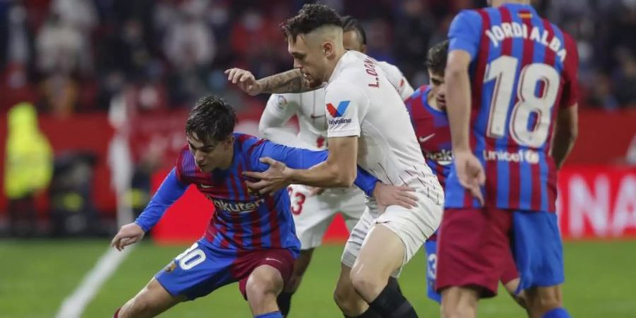 Lucas Ocampos (M) vom FC Sevilla gegen Gavi (l) vom FC Barcelona. Foto: Angel Fernandez/AP/dpa