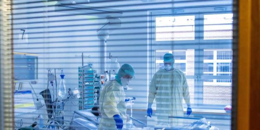 Ein an Covid-19 erkrankter Patient in einem Zimmer des besonders geschützten Teils einer Intensivstation. Foto: Jens Büttner/dpa