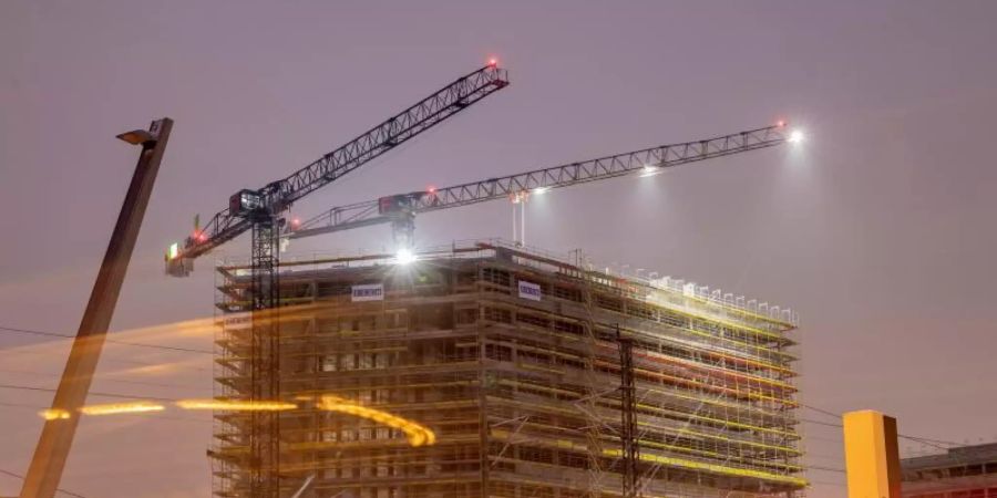 Baukräne an einer Baustelle in Berlin: Die Notenbank rechnet mit einem deutlich schwächeren Wachstum in diesem und im kommenden Jahr. Foto: Christoph Soeder/dpa