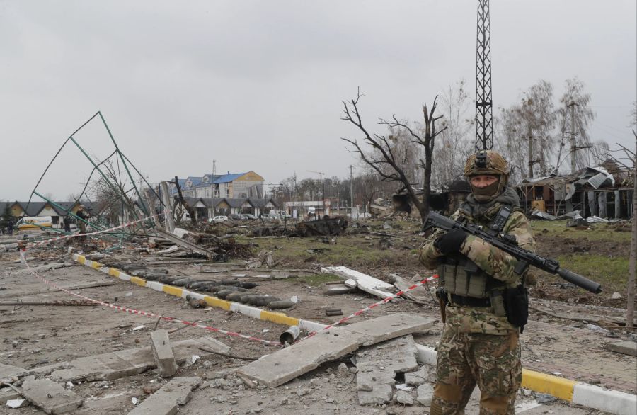 Ein Bild vom 5. April 2022, das während eines von den Kiewer Behörden organisierten Besuchs in Butscha aufgenommen wurde, zeigt einen ukrainischen Soldaten auf einer beschädigten Strasse.