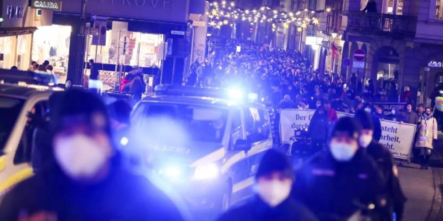 Demonstrationsteilnehmer in Begleitung der Polizei in der Innenstadt von Lübeck. Foto: Christian Charisius/dpa