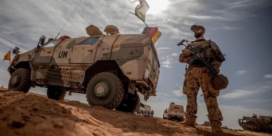 Ein Soldat der Bundeswehr steht in Mali neben einem Militärfahrzeug. Foto: Michael Kappeler/dpa/Archivbild