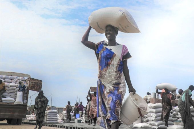 Millionen von Geflüchteten in Afrika sind auf die Verteilung von Lebensmitteln angewiesen, um zu überleben. Schwarze Frau erhält Lebensmittel