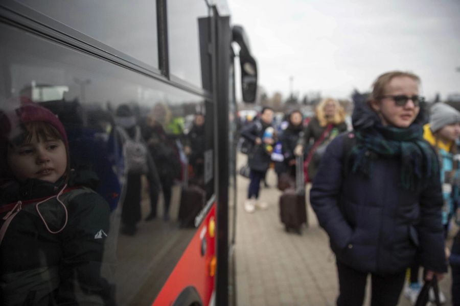 Flüchtlinge, vor allem Frauen mit Kindern, warten am 6. März 2022 beim polnischen Grenzübergang Medyka darauf, mit Bussen weiterzuziehen.