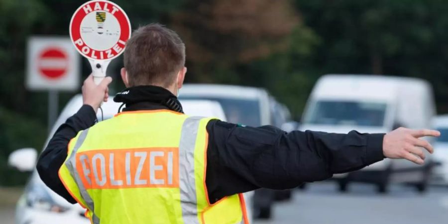 Ein Polizist steht im Rahmen eines Kontrolleinsatzes auf einem Autobahn-Parkplatz. Foto: Sebastian Kahnert/dpa-Zentralbild/dpa