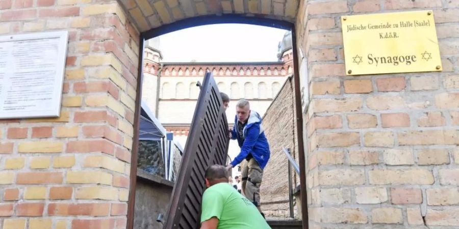Tischlermeister Thomas Thiele (vorn) hatte die Tür einst für die Synagoge gefertigt. Sie erlangte am 09. Oktober 2019 traurige Berühmtheit, als der Attentäter von Halle in die Synagoge eindringen wollte. Foto: Hendrik Schmidt/dpa-Zentralbild/dpa