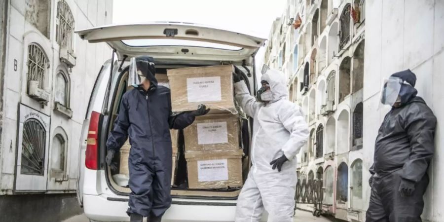 Arbeiter mit den Särgen von Corona-Toten auf einem Friedhof in Lima