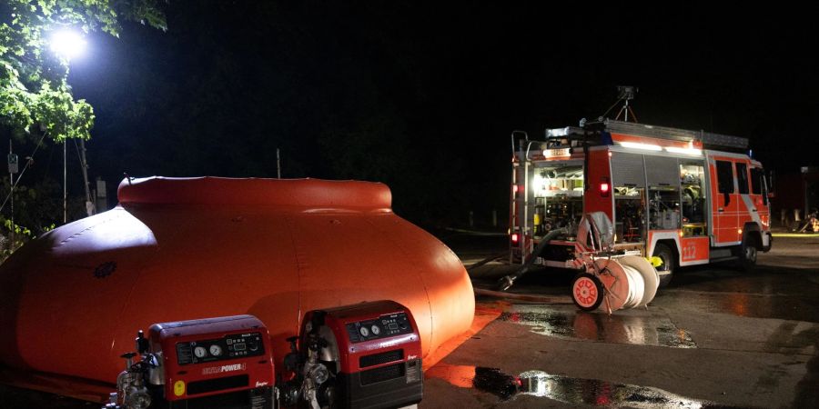 Die Feuerwehr füllt Löschwasser in eine sogenannte Blase (links) und leitet sie von dort mit Pumpen zum Brand.