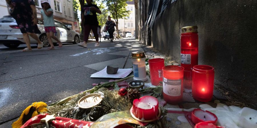 Trauer-Blumen und Kerzen erinnern an den Tod eines 16-jährigen Jugendlichen. Auch Tage nach den tödlichen Schüssen aus einer Polizei-Maschinenpistole auf einen 16-Jährigen wird heftig über den Fall diskutiert.