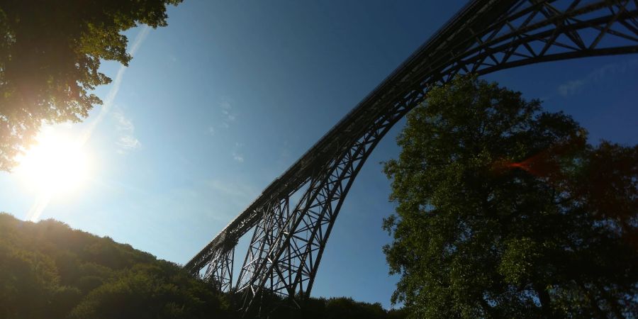 Die Müngstener Eisenbahnbrücke, eine Bogenfachwerkbrücke aus Stahl, führt über ein Tal der Wupper.