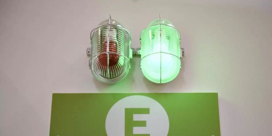 Eine grüne Lampe leuchtet am Eingang eines Impfzentrums. Experten gehen davon aus, dass eine Herdenimmunität gegen das Coronavirus ohne die Impfung von Kindern und Jugendlichen nicht erreichbar ist. Foto: Christopher Neundorf/dpa