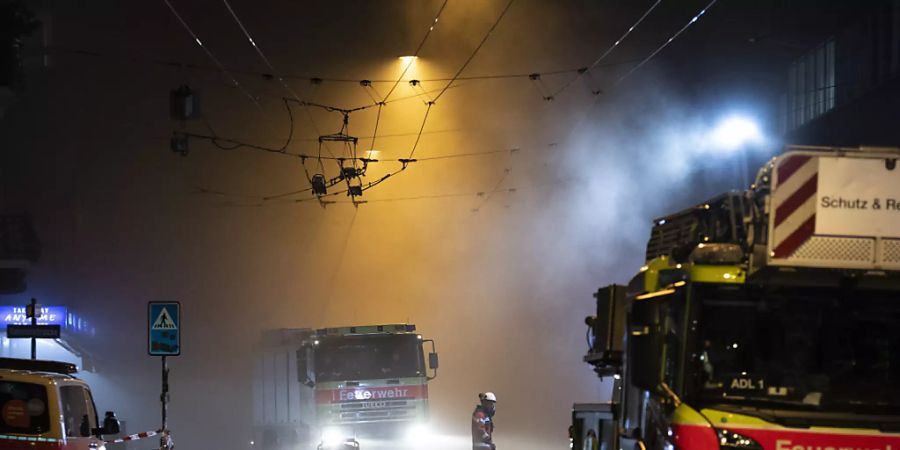 Ein Feuerwehrmann lauft durch den dichten Rauch in der Zürcher Langstrasse. Erst am späten Abend war das Feuer unter Kontrolle.