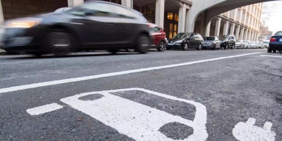 Ein Symbol für ein Elektroauto markiert einen Parkplatz neben einer E-Ladesäule. Foto: Julian Stratenschulte/dpa