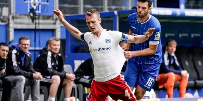 Sebastian Schonlau vom HSV wird von Darmstadts Luca Pfeiffer zu Boden gebracht. HSV