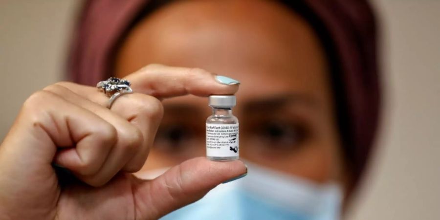 Mitarbeiterin der Gesundheitsdienste zeigt Impfdosis