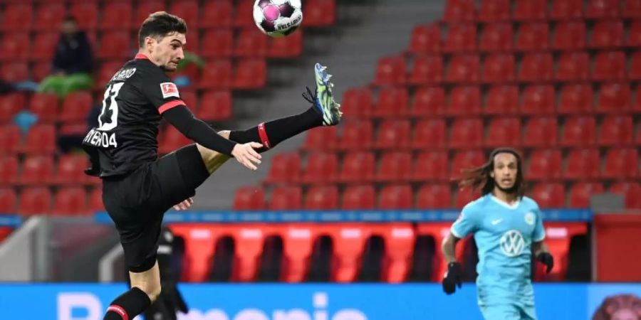 Leverkusens Lucas Alario (l) nimmt den Ball artistisch in der Luft an. Foto: Ina Fassbender/AFP/Pool/dpa