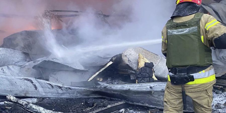 HANDOUT - Auf diesem vom ukrainischen Katastrophenschutz via AP zur Verfügung gestellten Foto arbeitet ein Feuerwehrmann daran, ein Feuer nach einem russischen Raketenangriff in Kryvyj Rih zu löschen. Foto: Uncredited/Ukrainian Emergency Service/AP/dpa - ACHTUNG: Nur zur redaktionellen Verwendung im Zusammenhang mit dem genannten Text und nur bei vollständiger Nennung des vorstehenden Credits