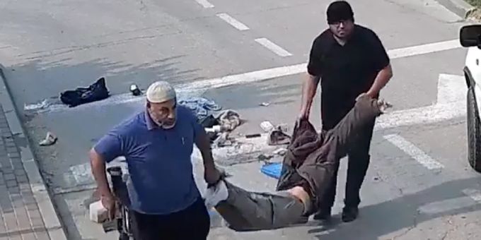 Der Mann rechts soll ein UN-Sozialarbeiter sein. Die beiden Männer transportieren die Leiche. UNRWA