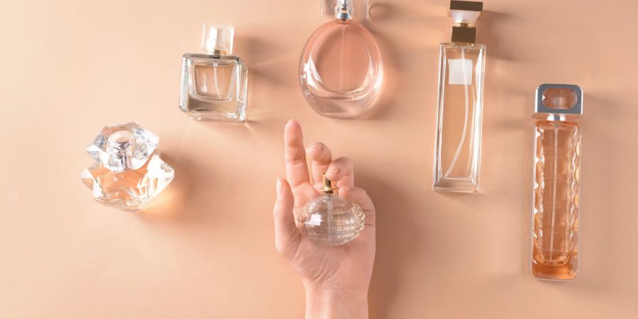 Parfums, Hand auf orangem Hintergrund