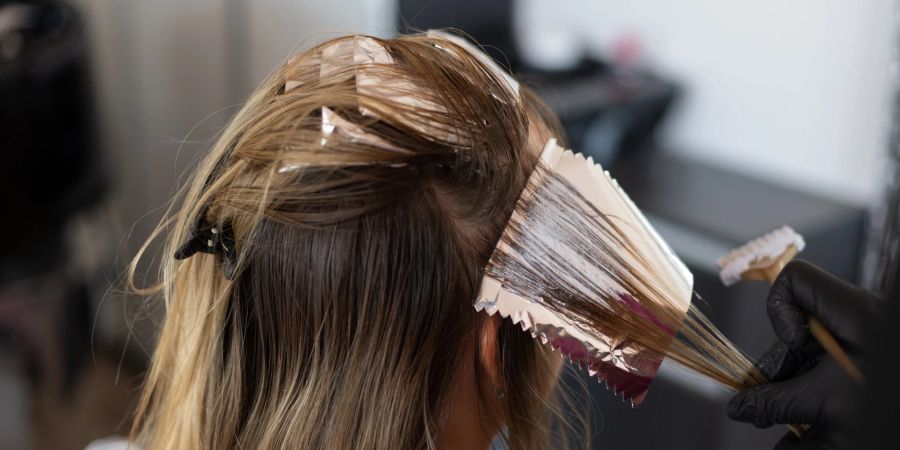 Eine Frau lässt sich die Haare färben.