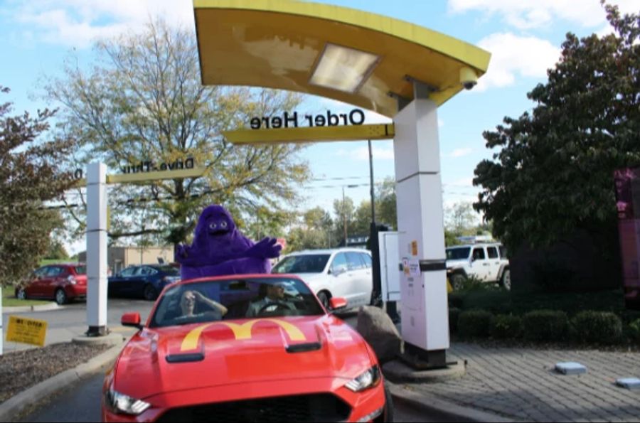 Das Münchner Paar durfte auch im schicken McDonalds-Ford-Mustang durch den Drive-in fahren – mit Maskottchen Grimace an Bord!