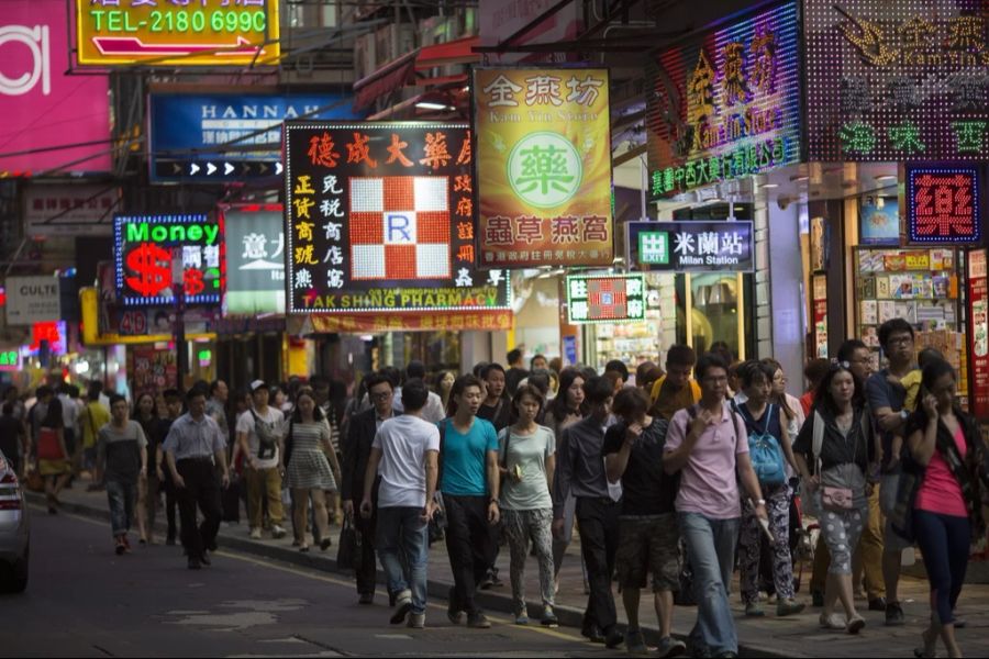 Menschen schlendern durch die Einkaufsmeile Tsim Sha Tsui in Hongkong.