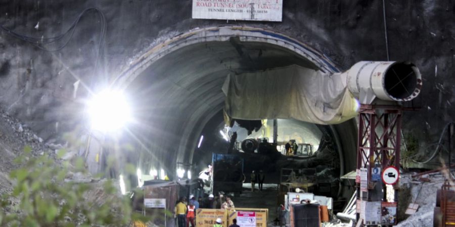 ARCHIV - Sicherheitspersonal bewacht den Eingang eines im Bau befindlichen Strassentunnels, der im indischen Bundesstaat Uttarakhand eingestürzt ist. Foto: AP/dpa