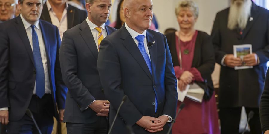 Christopher Luxon (M), Premierminister von Neuseeland, steht während der Vereidigungszeremonie im Government House in Wellington. Foto: Mark Mitchell/New Zealand Herald via AP/dpa - ACHTUNG: Nur zur redaktionellen Verwendung bis zum 12. Dezember und nur mit vollständiger Nennung des vorstehenden Credits.