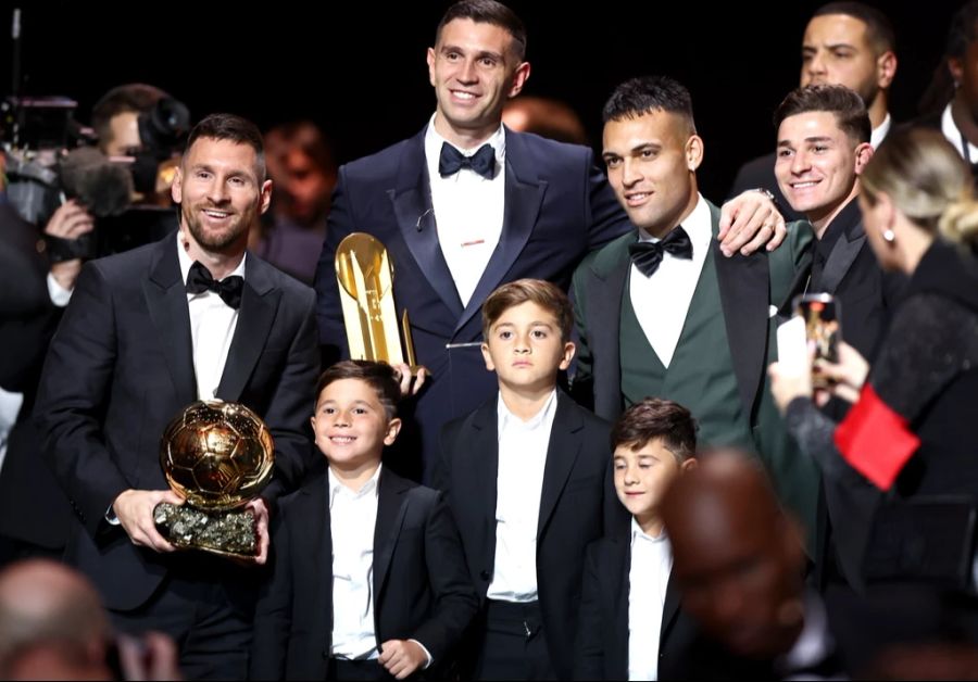 Lionel Messi feiert den Gewinn des Ballon d'Or auf der Bühne mit seinen drei Söhnen und den argentinischen Teamkameraden.