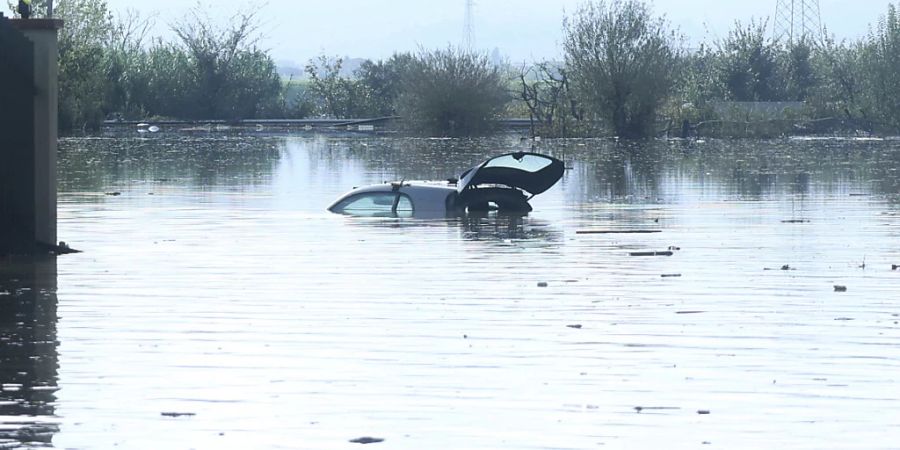 Nach heftigen Regenfällen ist ein Auto in den Fluten versunken. Foto: Adriano Conte/LaPresse/AP/dpa