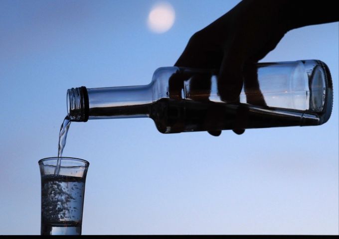 Nicht nur Wein, auch Edeldestillate können ein Essen für Gäste begleiten. Allerdings darf man keine Angst vor starken Aromen haben. Flasche Hand Schnapsglas Flüssigkeit transparent