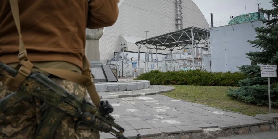 Ein ukrainischer Soldat steht vor dem Sarkophag, der den explodierten Reaktor im Kernkraftwerk Tschernobyl abdeckt.