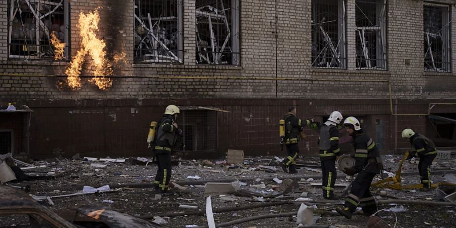 dpatopbilder - Feuerwehrleute löschen nach einem russischen Angriff in Charkiw mehrere Brände. Foto: Felipe Dana/AP/dpa