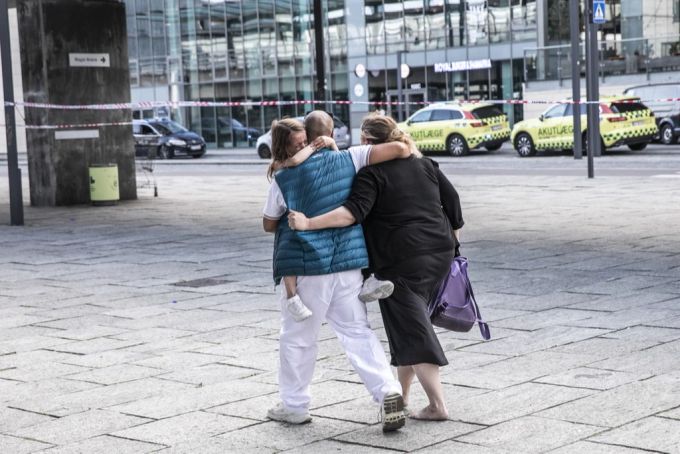 Drei Personen umarmen sich vor dem Fields-Einkaufszentrum in Kopenhagen. (EPA/Olafur Steinar Rye Gestsson) kopenhagen