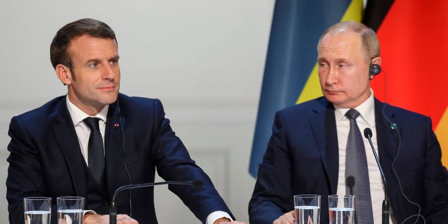 Emmanuel Macron (l), Präsident von Frankreich, und Wladimir Putin, Präsident von Russland, sitzen bei einer gemeinsamen Pressekonferenz im Pariser Schloss Elysee.