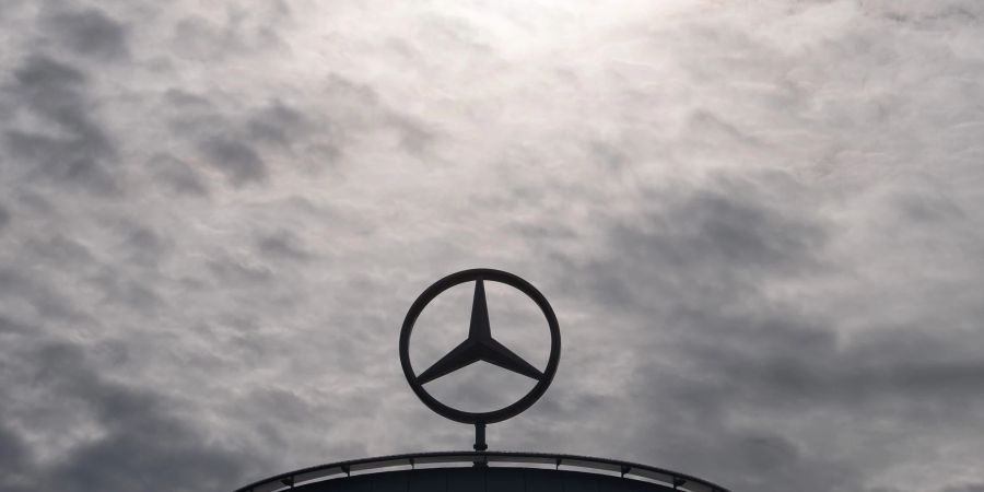 Ein Mercedes-Stern, das Logo der Marke Mercedes-Benz, steht auf einem Showroom.