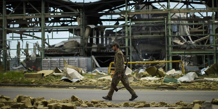 Ein ukrainischer Soldat geht an einer durch Beschuss zerstörten Gipsfabrik vorbei. Foto: Francisco Seco/AP/dpa