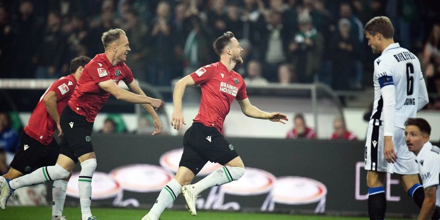 Hannovers Cedric Teuchert (M) jubelt nach seinem Treffer zum 1:0 mit Havard Nielsen (l), rechts steht Bielefelds Oliver Hüsing.