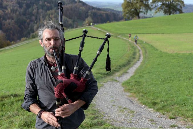 Dudelsackspieler Thom spielt auf der Strecke für die Athleten auf.